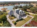 Aerial view of a large estate home, surrounded by mature trees, lake, and manicured lawns at 8570 Nw 31St Lane Rd, Ocala, FL 34482