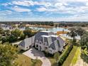Aerial view of a lakefront home with beautiful landscaping and a circular driveway at 8570 Nw 31St Lane Rd, Ocala, FL 34482