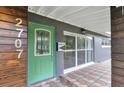 Stylish front entrance showcasing a green door, modern house number, and a unique tiled porch area at 2707 Illinois St, Orlando, FL 32803