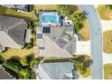 Aerial view of a single Gathering home showcasing a screened-in pool, patio area, solar panels, and a landscaped yard at 3303 Ridgewood Path, The Villages, FL 32163