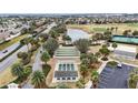 An aerial view of community shuffleboard courts, bocce ball courts, lake and a golf course at 2378 Ridgeway Ct, The Villages, FL 32162
