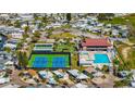 An aerial view showcases the active community with a pool, clubhouse, tennis courts, and beautiful landscaping at 9000 Us Highway 192 # 242, Clermont, FL 34714