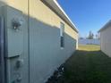 Side view of a house with an exterior electrical box and a small window at 357 Summershore Dr, Auburndale, FL 33823