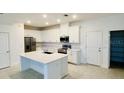 Modern kitchen featuring white cabinets, stainless steel appliances, and a spacious island at 3842 Knotty Pine St, St Cloud, FL 34772