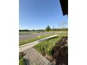 Manicured front yard with stone walkway leading toward a lake, showcasing a peaceful community setting at 3842 Knotty Pine St, St Cloud, FL 34772
