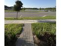 Manicured front yard with stone walkway leading toward a lake, showcasing a peaceful community setting at 3842 Knotty Pine St, St Cloud, FL 34772