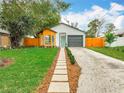 Charming home features a light blue front door, a gray garage door, and a unique wood accent wall at 748 Neuse Ave, Orlando, FL 32804