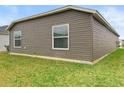 Back exterior of home featuring neutral siding, and green lawn at 3575 Cochran St, The Villages, FL 32163