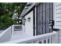 Up close view of the front entryway with black security door, white railing and painted deck boards at 608 Grand St, Orlando, FL 32805