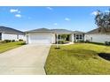 Charming single-story home with well-manicured lawn, inviting curb appeal, and driveway at 3381 Harris Ct, The Villages, FL 32163