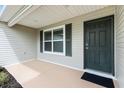 Inviting covered front porch featuring a dark front door and adjacent window with shutters at 3381 Harris Ct, The Villages, FL 32163