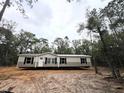 Single-story home nestled amongst pine trees, featuring neutral siding and a welcoming front door at 10129 Sw 157Th Ln, Dunnellon, FL 34432