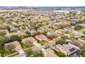 Aerial view of a residential neighborhood highlighting the property boundaries with surrounding homes and trees at 1086 Harmony Ln, Clermont, FL 34711