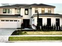 Attractive home featuring manicured landscaping and a spacious two-car garage, complemented by clean architectural lines at 16832 Bolsena Dr, Bella Collina, FL 34756