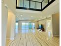 Bright living room boasting hardwood floors, expansive windows, and breathtaking lake views at 16832 Bolsena Dr, Bella Collina, FL 34756