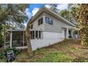Side view of home exterior showing screened porch, yard, and architectural details at 1630 Lakeview Ct, Eustis, FL 32726