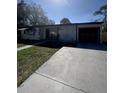 Street view of a cozy, single-Gathering home featuring an attached garage and well-manicured lawn at 574 E Normandy Blvd, Deltona, FL 32725