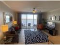 Cozy living room featuring a comfortable sofa and a view to the balcony with chairs at 13415 Blue Heron Beach Dr # 1407, Orlando, FL 32821