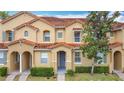 Townhome exterior boasts terra cotta roof, neutral paint, well-manicured landscaping, and inviting facade at 2634 Andros Ln, Kissimmee, FL 34747
