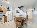 Cozy kitchen featuring tile floors, white appliances, light wood cabinets, and a charming breakfast nook at 2634 Andros Ln, Kissimmee, FL 34747