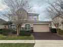 This exterior shot shows a two-car garage with a neutral-toned door and decorative brick driveway at 1678 Swallowtail Ln, Sanford, FL 32771
