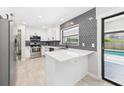 Modern kitchen with white cabinets, stainless steel appliances, and a view to the pool at 1776 E Cheryl Dr, Winter Park, FL 32792
