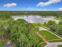 An aerial view of the property showcasing the home's location near a lake surrounded by lush greenery at 318 Mitnik Dr, Deltona, FL 32738