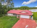 Aerial view of home with red roof, stone accents, and an attached two-car garage at 318 Mitnik Dr, Deltona, FL 32738