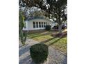 Charming single-story home featuring well-maintained landscaping and a blue accent roof at 910 Orchid St, Lady Lake, FL 32159
