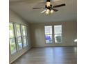Bright living room with lots of natural light, a ceiling fan, and wood-look floors at 910 Orchid St, Lady Lake, FL 32159