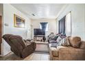 Cozy living room featuring tile flooring, a sofa, a TV, and a comfortable recliner chair at 1222 Avenue M, Haines City, FL 33844