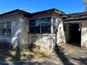 Exterior view of a neglected home featuring a boarded window, deteriorating paint, and a weathered facade at 1075 Merritt St, Altamonte Springs, FL 32701