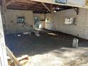 Interior view of a garage, showing its disrepair with debris, broken windows, and exposed beams at 1075 Merritt St, Altamonte Springs, FL 32701