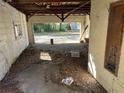 Interior of a dilapidated two car garage filled with leaves, trash, and damaged fixtures at 1075 Merritt St, Altamonte Springs, FL 32701