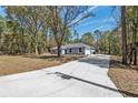 Long, private driveway leads to a well-maintained home with an attached garage at 5593 Sw 199Th Ct, Dunnellon, FL 34431