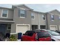 Close-up of a townhouse exterior showing a garage, front door, and neutral gray color scheme at 1026 Lido Dr, Howey In The Hills, FL 34737