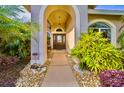 Inviting front entryway with a gorgeous stone walkway, lush landscaping, and decorative plants at 4435 Fairway Oaks Dr, Mulberry, FL 33860
