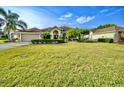 Beautiful single-story home with a luscious lawn, palm trees and immaculate landscaping at 4435 Fairway Oaks Dr, Mulberry, FL 33860