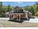 Exterior view of the home showcasing the balcony, garage, and brick-paved carport at 445 Se 98Th Ave, Webster, FL 33597