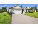 Single-story home showcasing a driveway, two-car garage, complemented by vibrant green lawn at 805 Baylor Dr, Deltona, FL 32725