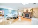Cozy living room featuring hardwood floors, a charming brick fireplace, and ample natural light at 568 Gainsboro St, Deltona, FL 32725