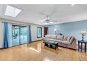 Bright living room with skylights, hardwood floors, and a sliding glass door that opens to the pool area at 568 Gainsboro St, Deltona, FL 32725