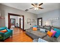 Inviting living room featuring hardwood floors, a plush sectional sofa, and an open doorway to the kitchen at 501 Washington Ave, Eustis, FL 32726