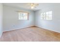 Bright bedroom features carpet, ceiling fan, and large windows for natural light, providing a relaxing space at 13729 Se 89Th Ave, Summerfield, FL 34491