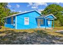 Side angle of a bright blue single story home with white trim at 1720 S Warnell Rd, Coleman, FL 33521