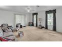 Bright living room with neutral carpet, ceiling fan, and plenty of natural light at 1606 Center St, Deland, FL 32720