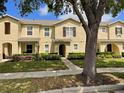 Three-unit stucco home featuring well-maintained landscaping and individual arched entryways at 387 Winter Nellis Cir, Winter Garden, FL 34787