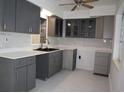 Modern kitchen featuring gray cabinets, quartz countertops, and stainless steel sink at 124 Auburn Rd, Auburndale, FL 33823