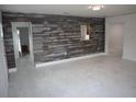 Spacious living room with hardwood accent wall and bright white floors and walls at 124 Auburn Rd, Auburndale, FL 33823