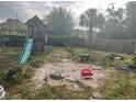 Backyard with a weathered playset and a sandy area at 1400 Hayward Ave, Deltona, FL 32738